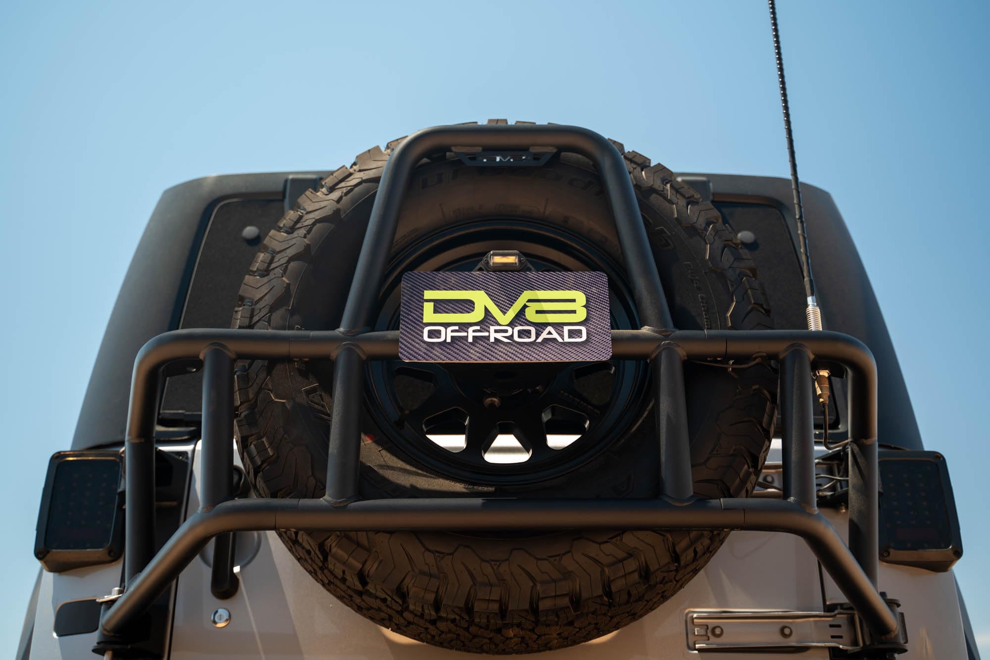 Tire Carrier Body Mounted for 2007-2018 Jeep Wrangler JK | Improves Departure Angle | Transfers Weight from The Door Hinges to The Vehicle Body | LED License Plate Light | 2 Whip Flag/Antenna Mounts