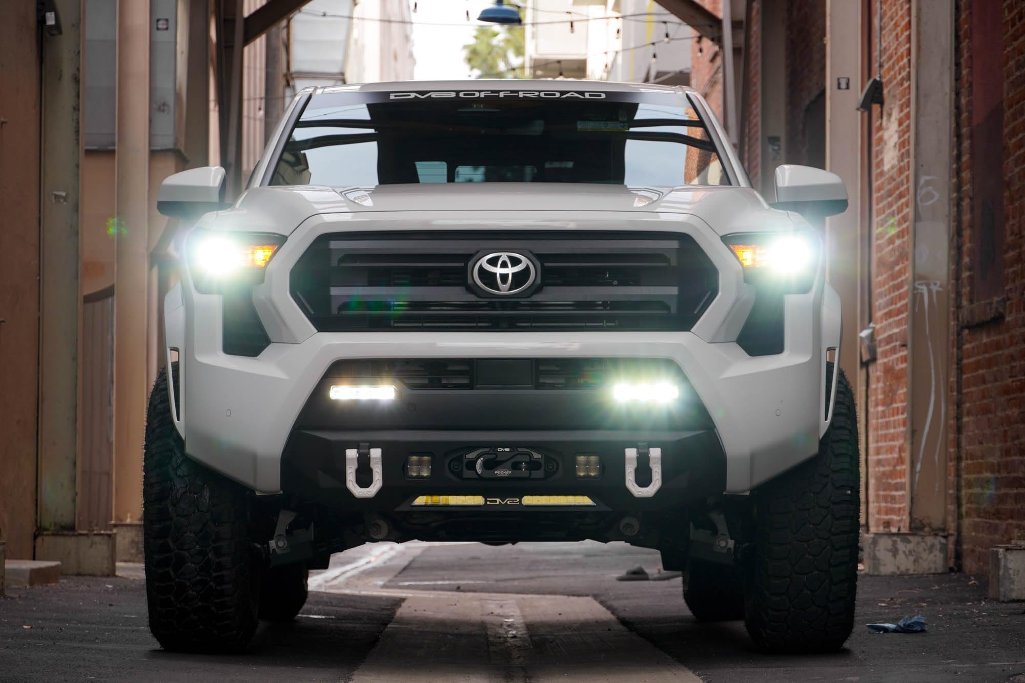 Front Bumper DV8 Centric for 2024 Toyota Tacoma | One 20-Inch Single Row Light Bar & Two 3-Inch Pod Light Mounts | Integrated Standard Winch & D-Ring Mounts | Micro-Texture Black Powder Coat Finish