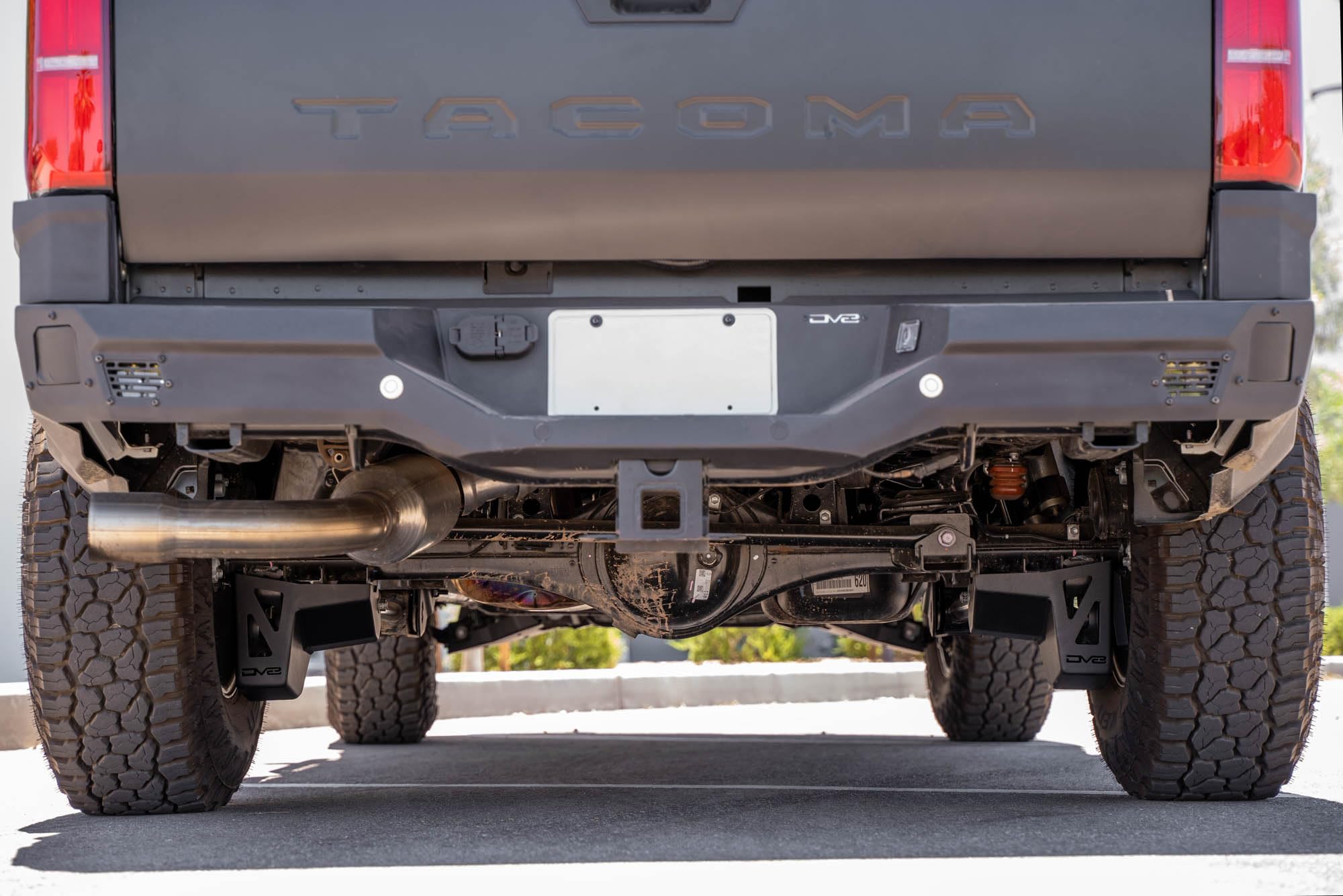 Rear Shock & Link Skid Plates DV8 for 2024 Toyota Tacoma | Protects Lower Shock Mount & Link | Built-in Drain Holes | Single Piece Design | Fully Bolt-On Installation | Black Powder Coat | 4mm Steel