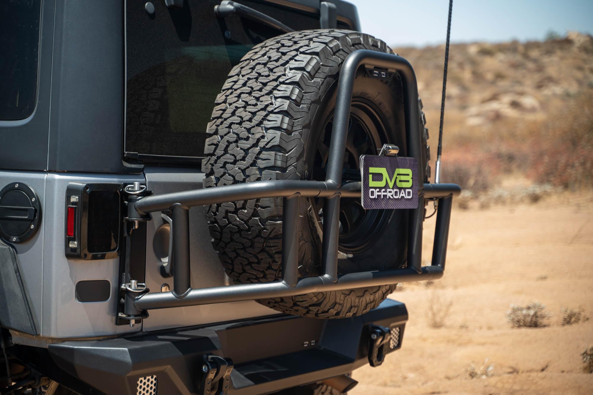 Tire Carrier Body Mounted for 2007-2018 Jeep Wrangler JK | Improves Departure Angle | Transfers Weight from The Door Hinges to The Vehicle Body | LED License Plate Light | 2 Whip Flag/Antenna Mounts