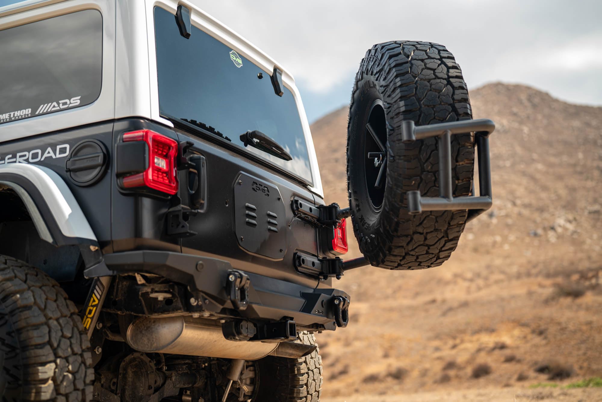 DV8 Offroad Tire Carrier Body Mounted for 2018-2025 Jeep Wrangler JL | Removes Weight of Spare from Door Hinges | Fits Up to a 40 x 13.50 Tire with a -25 Max Offset | Improves Departure Angle | Steel