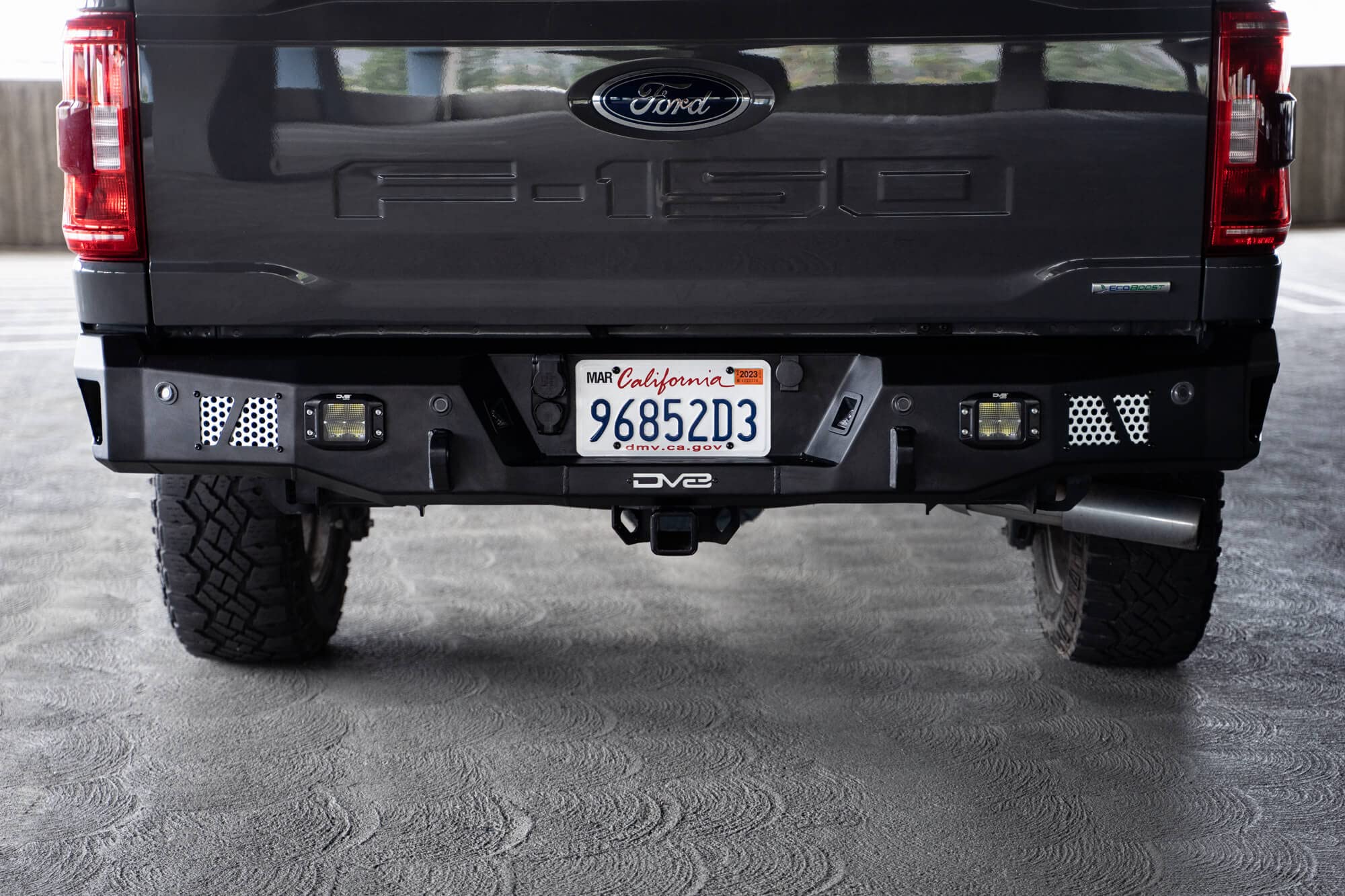 MTO Series DV8 Offroad Rear Bumper for 2021-2025 Ford F-150 | Utility Steps | Designed for Single Exhaust Setups | Accepts (2) 3" Flush Mount Pod Lights | Paintable Aluminum Inserts